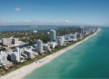 Aerial view of city buildings near Miami shoreline, Pitbull Conference hosted in Miami FL